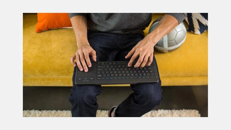  Microsoft All-in-One Media Keyboard – mężczyzna korzystający z klawiatury na kanapie 